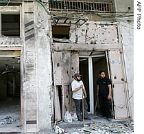 Palestinians clean the rubble at a damaged money-changing office following an Israeli air strike in Gaza City, 25 May 2007