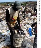 A scavenger at Dakar's dump collects trash to sell