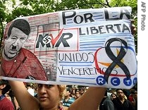 A demonstrator holds a sign against Venezuelan President Hugo Chavez during a protest against the closure of private network RCTV (Radio Caracas Television) in Caracas, 29 May 2007