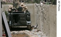 Lebanese army's armored personnel carrier behind a shattered wall in Tripoli, 29 May 2007