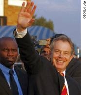 Tony Blair, right, waves during a visit to local local community radio station in Soweto, South Africa, 31 May 2007