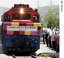 A train passes the gate for the Demilitarized Zone as South Koreans wave unification flags near Dorasan Station near the Demilitarized Zone (DMZ) of Panmunjom, in Paju, north of Seoul, South Korea, 17 May 2007