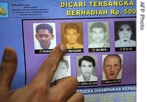 Police spokesman Sisno Adiwinoto points to a picture of Abu Dujana printed in a most wanted poster during a press briefing in Jakarta, 13 Jun 2007 