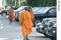 Cambodian Buddhist monks glance at vehicles owned by Cambodian lawmakers near the National Assembly in Phnom Penh, 20 June 2007