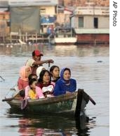 Muslim women dressed up for Eid, ride in a water taxi towards Sunda Kelapa harbor for Eid prayers in Jakarta (File Photo)