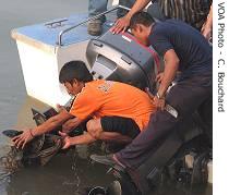 A worker clears garbage from the engine