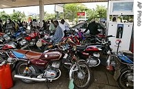 People stand next to their motor bikes as they await fuel to arrive during a nationwide general strike in Lagos, 21 Jun 2007