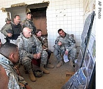 Lieutenant General Raymond Odierno, center, is briefed by a field commander at a bombed-out hospital in Baqouba, Iraq, 21 June 2007