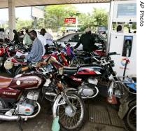People stand next to their motor bikes as they await fuel to arrive during a nationwide general strike in Lagos, Nigeria, 21 Jun 2007
