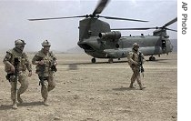 Canadian soldiers, part of the NATO forces, walk in front of a Chinook helicopter after recapturing Ghorak district from Taleban fighters in Kandahar province, south of Kabul, June 25, 2007