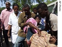 An elderly Somali woman is carried by after she was injured in a roadside bomb attack, in Mogadishu, Somalia, 26 Jun 2007