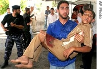 Palestinian man carries wounded boy at Shifa hospital in Gaza City