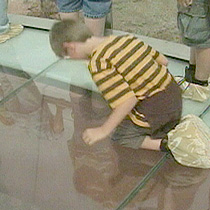 A boy looks down into the Grand Canyon from the Skywalk's glass floor