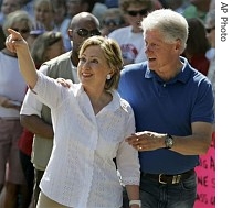 Former President Bill Clinton talks to his wife, Democratic presidential hopeful US Senator Hillary Clinton as she acknowledges supporters at the Fourth of July Parade Wednesday in Clear Lake, Iowa, 4 July 2007