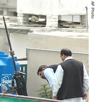 Pakistani security officials examine a long barreled anti-aircraft gun found on the rooftop of a house in Rawalpindi, 6 Jul 2007