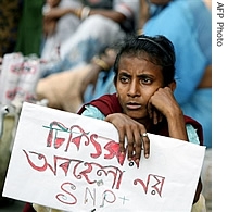 An Indian woman hold a poster saying 'Do not neglect the treatment' as she takes part in an HIV awareness rally in Kolkata, 11 June 2007