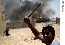 An Iraqi youth reacts as a US military's Bradley fighting vehicle bursts into flames in Obeidi, in south east Baghdad, 2 Jul 2007