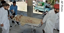 A Pakistani paramedic gives initial treatment to a soldier injured in the suicide bombing, at a local hospital in Matta,  Sunday, 15 July 2007