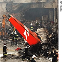 Firefighters work at the site where a TAM airlines commercial jet crashed in Sao Paulo, 18 July 2007