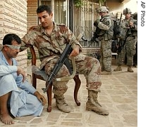 A suspected terrorist is detained by Iraqi Army soldiers as US soldiers search his home in Baqouba, 60 kilometers (35 miles) northeast of Baghdad, Iraq, 20 July 2007