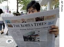 South Korean man reads a newspaper reporting South Koreans kidnapped in Afghanistan in downtown Seoul, 22 Jul 2007