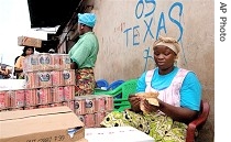 Angolese worker counts her money in Luanda (file photo)