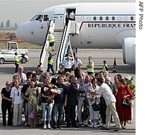 The Bulgarian nurses and medic pose in front of the French presidential plane after their arrival at the Sofia airport, 24 July 2007