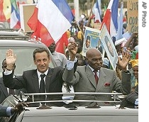 French President Nicolas Sarkozy and Senegalese President Abdoulaye Wade wave from an open car during a motorcade through Dakar, 26 July 2007