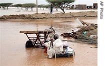 A Sudanese sits amongst the remains of his home following floods in Kassala, near Khartoum, Sudan Tuesday, 10 July 2007