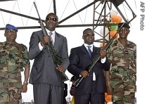 Ivorian President Laurent Gbagbo (2ndL) and PM Guillaume Soro (2ndR) pose with the rifles they were given, during a disarmament and reconciliation ceremony, 30 Jul7 2007