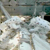 Astronauts work on the International Space Station
