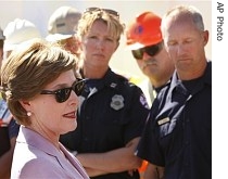 First Lady Laura Bush talks to first responders as she visits the site of the I-35W bridge collapse over the Mississippi River in Minneapolis, 3 Aug. 2007