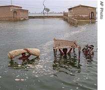 Pakistani villagers move out from a flooded area in Shahdad Kot district near Hyderabad, in Pakistan, 03 Jul 2007