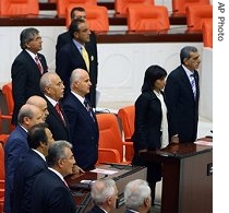 Newly elected Turkish and Kurdish lawmakers sing the national anthem during the opening session of the new Parliament in Ankara