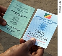 A man shows a student card (L) and a newly-printed election voting card specially introduced for the Congolese second round of legislative elections in Brazzaville, 05 Aug 2007