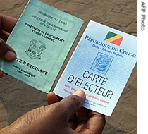 A man shows a student card (L) and a newly-printed election voting card specially introduced for the Congolese second round of legislative elections in Brazzaville, 05 Aug 2007