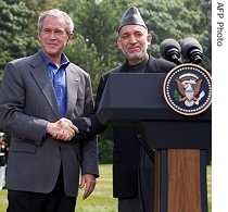 Afghan President Hamid Karzai (r) and U.S. President Bush shake hands following a joint press conference at Camp David, 06 Aug 2007