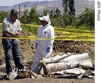 Georgian specialists examine the remains of the rocket near Tsitelubani, South Ossetia, Georgia, 07 Aug. 2007
