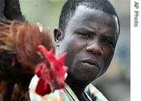 A chicken trader holds up a bird to be sold at a market in Lagos, Nigeria