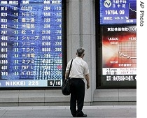 A Japanese businessman looks at a stock indicator in Tokyo, 10 Aug 2007<br />