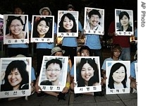 South Korean protesters hold pictures of the remaining 21 kidnapped South Koreans in Afghanistan at a candlelight rally, 3 Aug. 2007