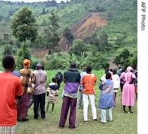 Residents of Kuvasali village watch from a distance a hillside scarred by a landslide in Kenya, 11 Aug 1007