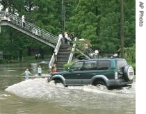A four-wheel-drive vehicle travels on a flooded street in Pyongyang, North Korea, 14 Aug 2007