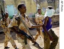 Somali government troops guard detain an Oromo Ethiopian separatist fighter loyal to Somalia's Islamic Court Union, in Baidoa, Somalia, 13 Dec 2006