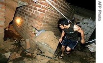 Man examines collapsed wall of building following earthquake in Lima, 16 Aug 2007
