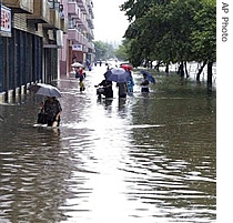 In this photo taken by Korean Central News Agency (KCNA), people wade through a flooded street in Pyongyang, North Korea, 11 Aug 2007