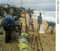 Liberians try to defend their homes from the rising tide with sandbags