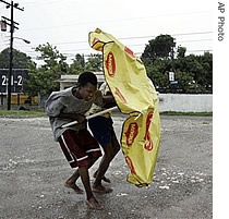 Young boys use an umbrella to resist the wind while walking at a street of Kingston during the pass of Hurricane Dean over Jamaica, 19 Aug 2007