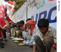 A man dressed as a Santa Claus distributes food to poor people, in Gauhati, India <br>(File Photo)