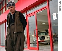 A Kurdish man walks out of a shop that sells brand new models of cars in downtown Irbil, northern Iraq, 16 Feb. 2005